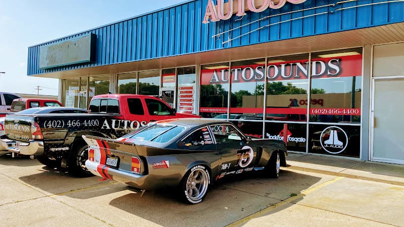 Blue metal storefront with a gray Vega coupe parked outside at Autosounds of Lincoln in Lincoln, Nebraska