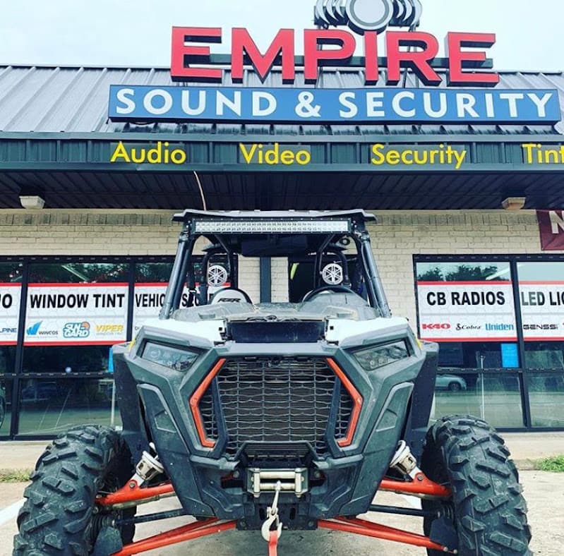 Off-road side-by-side in front of storefront at Empire Sound & Security Car Audio / Window Tint in McKinney, Texas