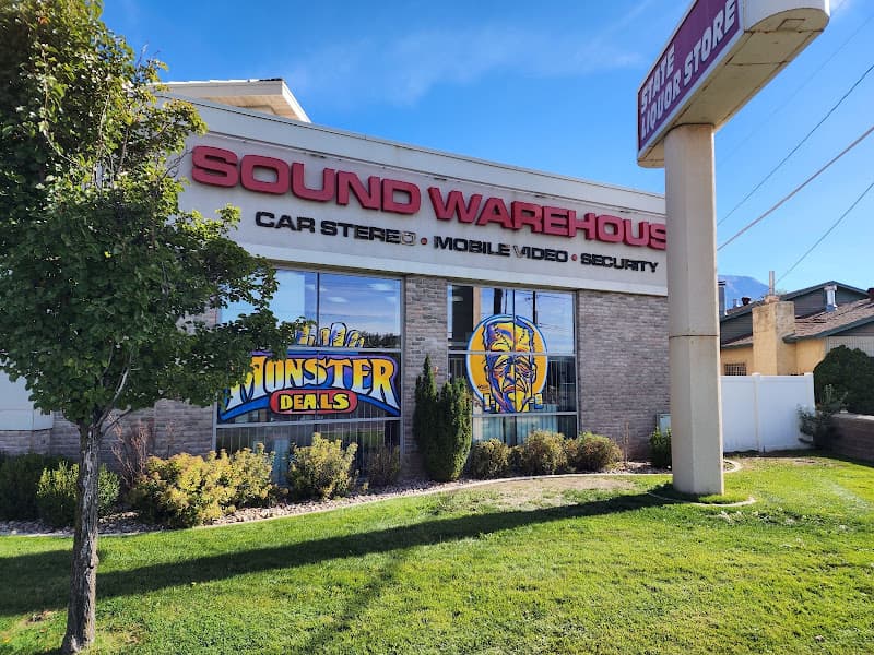 Brick storefront with red sign and Monster Deals window decal at Sound Warehouse in Orem, Utah