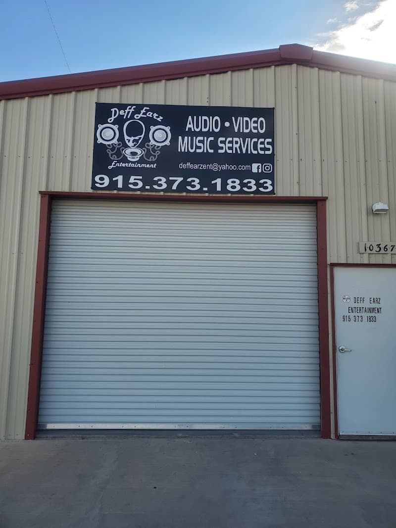Metal building with roll-up door and audio video sign at Deff Earz Entertainment LLC in Socorro, Texas
