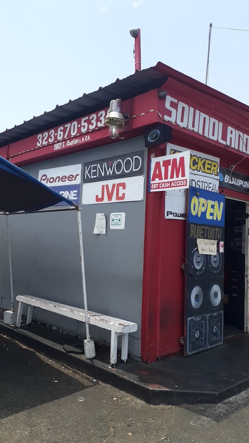 Red storefront with Kenwood, JVC and Pioneer signs and a bench at Soundland auto Stereo in Los Angeles, California