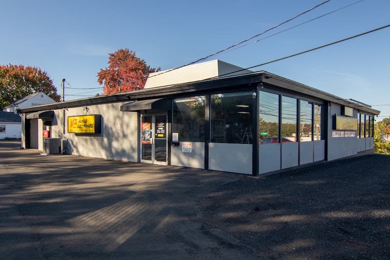 Storefront with yellow sign and large front windows at Mobile Electronics in Meriden, Connecticut