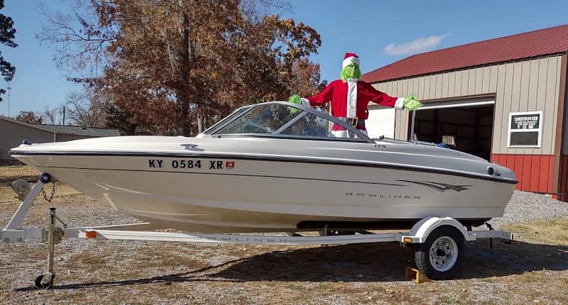 White motorboat on a trailer with a Grinch figure at Sunset Blvd Music in Murray, Kentucky