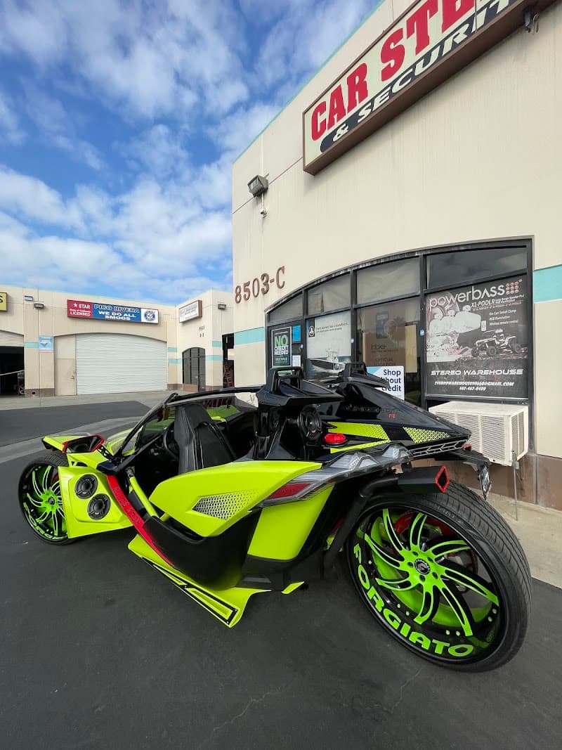 Lime green three-wheel roadster parked outside a storefront at Stereo Warehouse in Pico Rivera, California